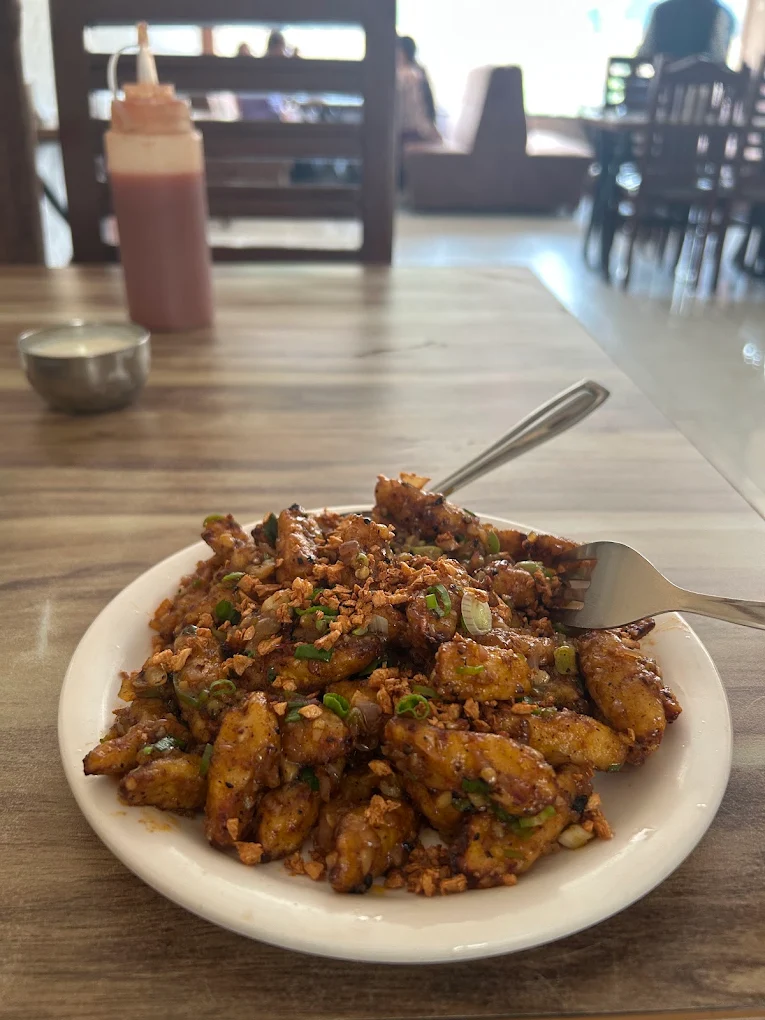 Wok-tossed chilli garlic potato garnished with spring onion